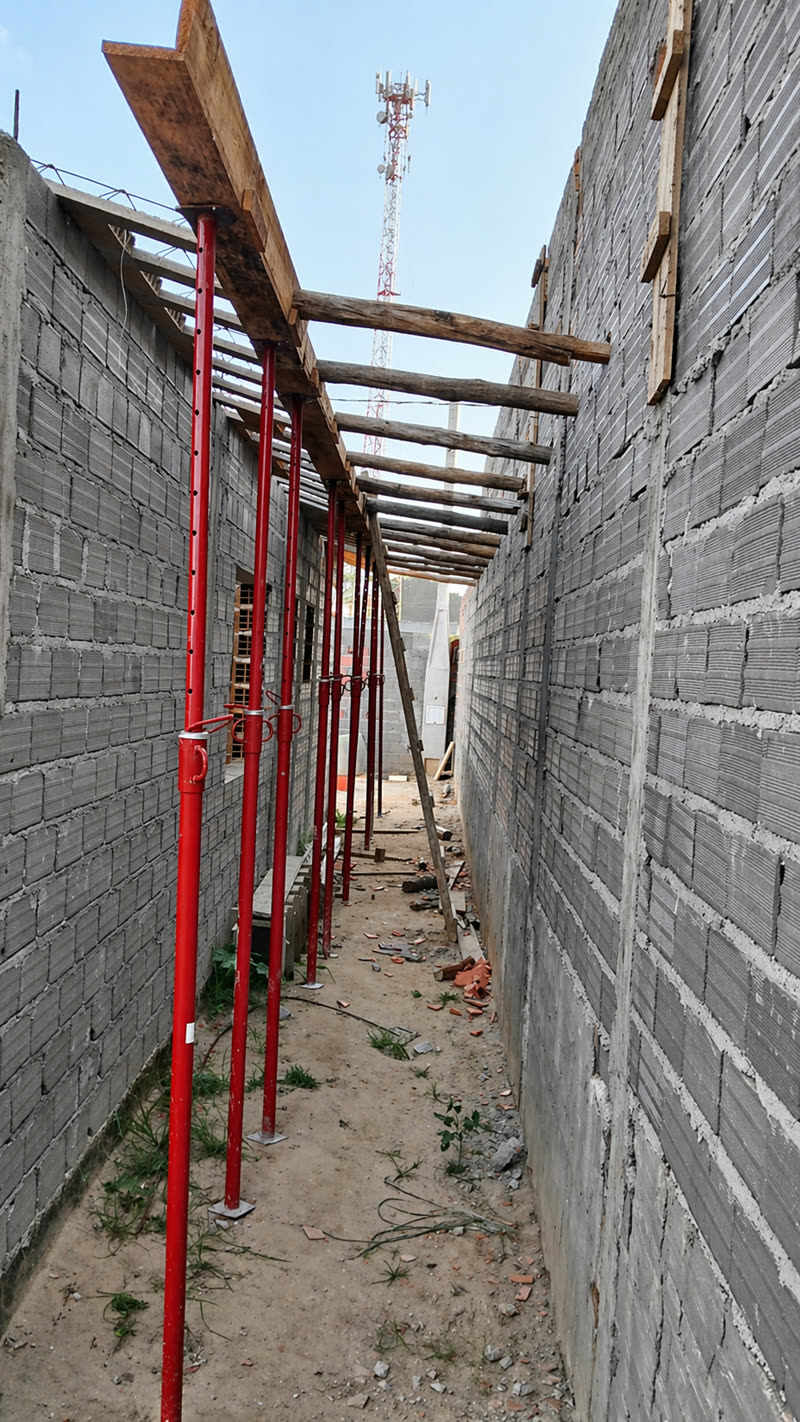 Escoras metálicas apoiando forma e passarela em corredor de obra